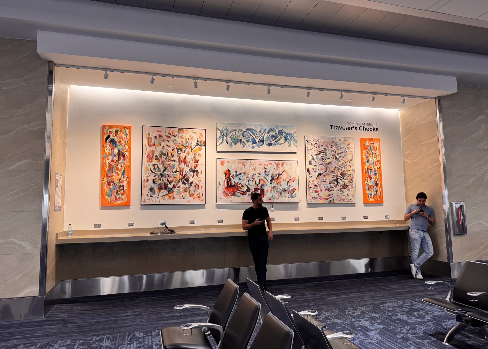 Images from the new "Traveler's Checks" art exhibition in Terminal 2 adorn the walls of a charging station in Concourse D at the Fort Lauderdale-Hollywood International Airport. 
